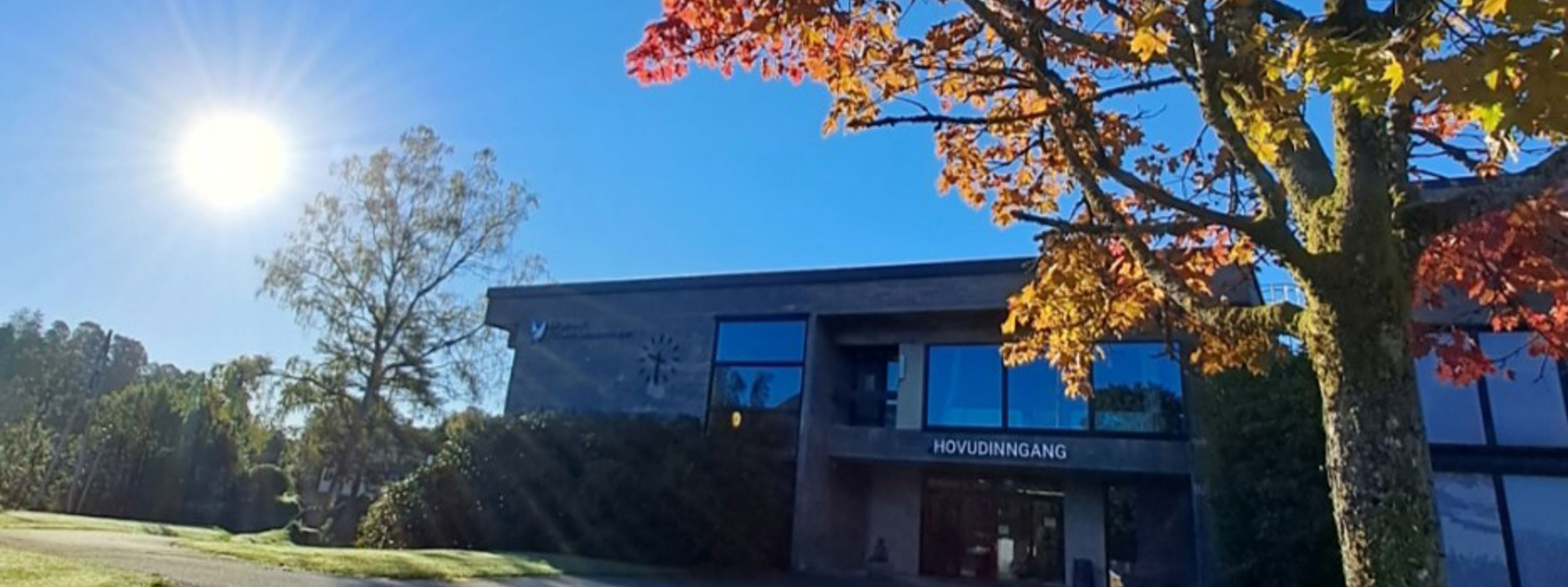 Biletet av framsida av skulen, med haustfargar.